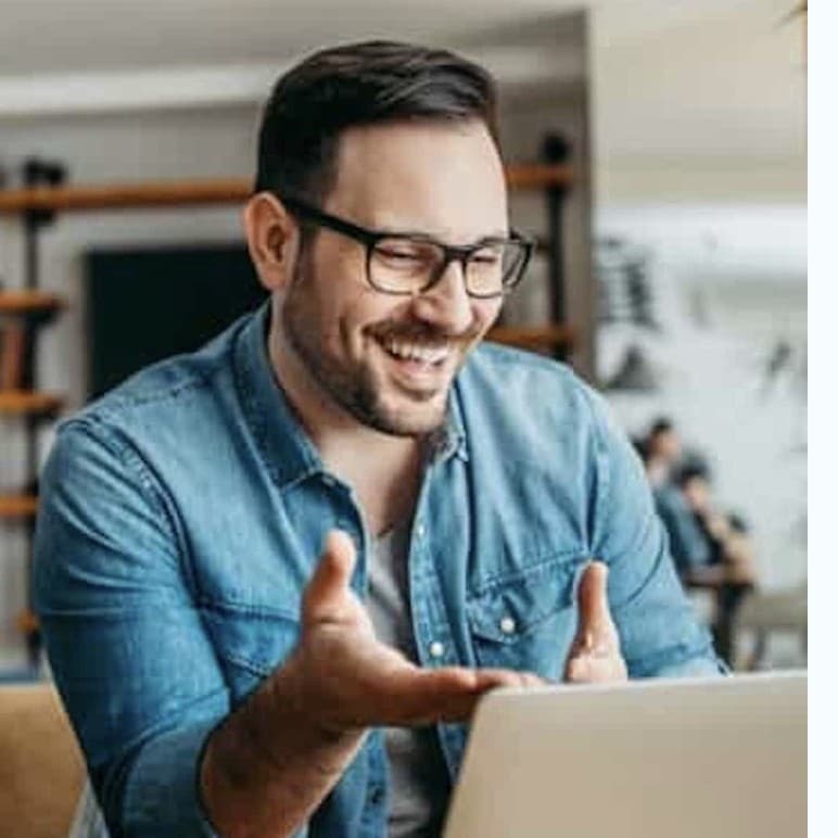 Lächelnder Mann am Laptop während einer Online-Weiterbildung